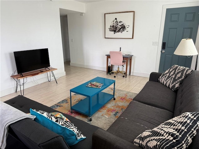 living area featuring baseboards and wood tiled floor