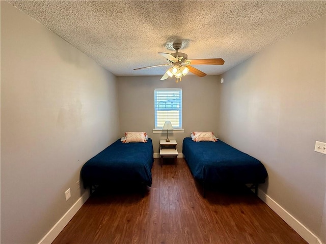 bedroom featuring a ceiling fan, a textured ceiling, baseboards, and wood finished floors