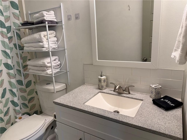 bathroom featuring toilet, a shower with curtain, tasteful backsplash, and vanity