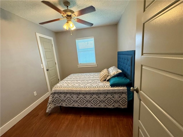 bedroom featuring a textured ceiling, ceiling fan, dark wood-type flooring, and baseboards