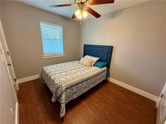 bedroom featuring ceiling fan, a textured ceiling, baseboards, and wood finished floors