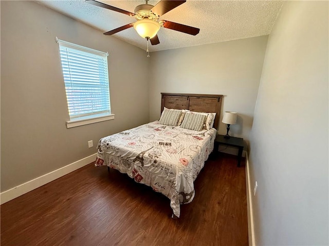 bedroom with a ceiling fan, a textured ceiling, baseboards, and wood finished floors