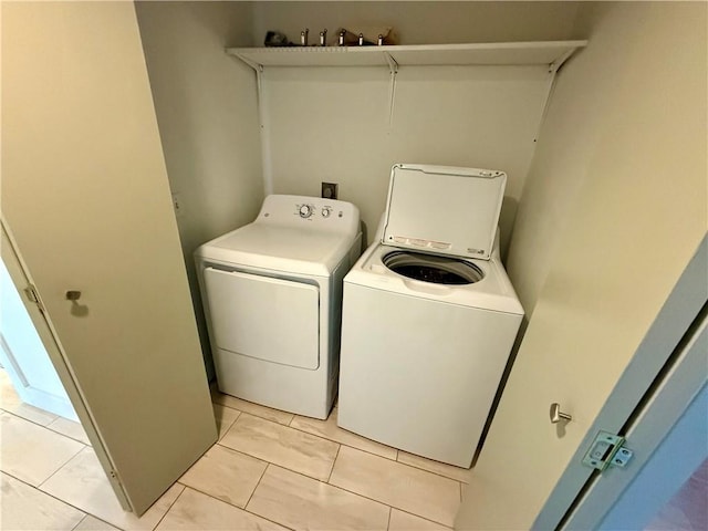 laundry area featuring washing machine and dryer, laundry area, and light tile patterned flooring