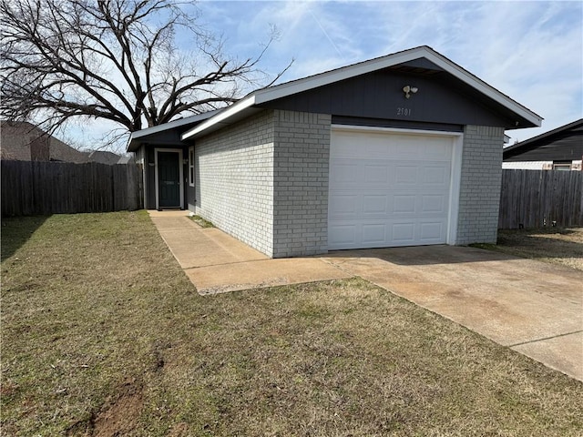 garage featuring concrete driveway and fence