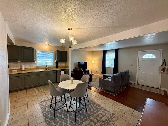 dining room featuring light tile patterned floors, plenty of natural light, a chandelier, and baseboards