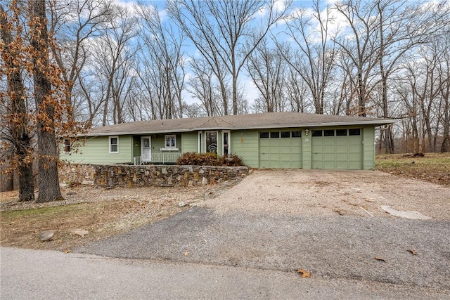 ranch-style house featuring aphalt driveway and an attached garage