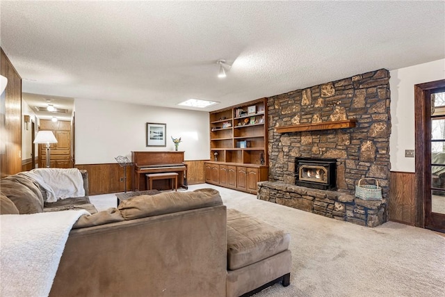 living area with a wainscoted wall, wood walls, a textured ceiling, and carpet