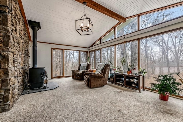 sunroom / solarium featuring a chandelier, a wood stove, and lofted ceiling with beams