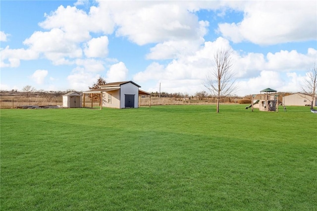 view of yard with a playground, a shed, a rural view, and an outdoor structure