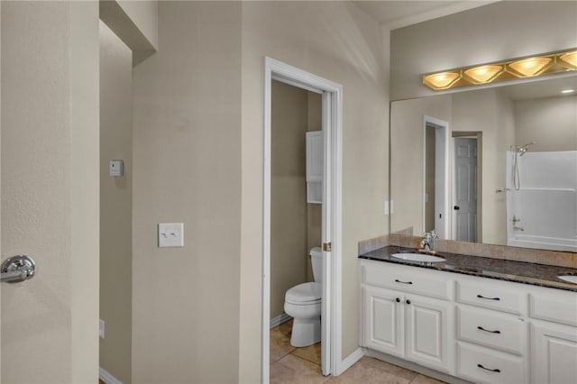 bathroom featuring double vanity, a sink, toilet, and tile patterned floors