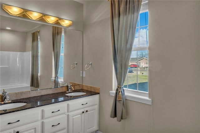 full bath with a sink and double vanity