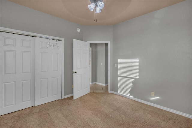 unfurnished bedroom featuring a closet, carpet flooring, a ceiling fan, and baseboards