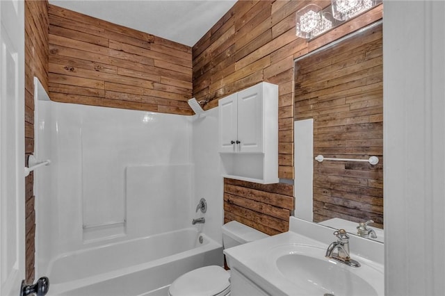 bathroom featuring toilet, wooden walls,  shower combination, and vanity