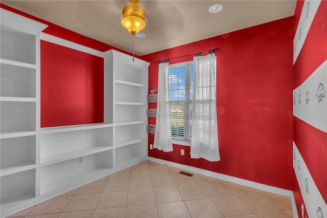 spare room with baseboards, visible vents, ceiling fan, and tile patterned floors