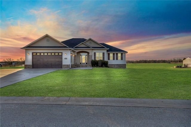 view of front of home with concrete driveway, a yard, and an attached garage