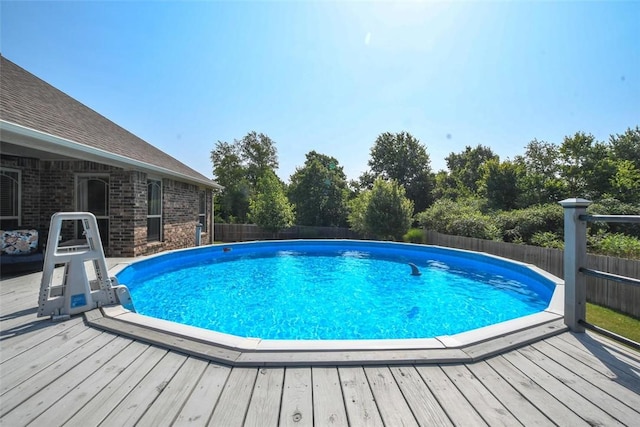 view of swimming pool featuring a fenced backyard, a deck, and a fenced in pool