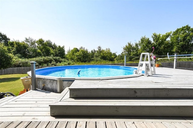 outdoor pool with fence and a deck