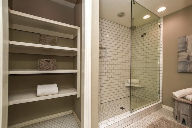 full bathroom featuring tile patterned flooring, baseboards, a tile shower, and built in features