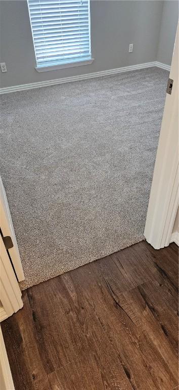 unfurnished room featuring dark wood-style flooring