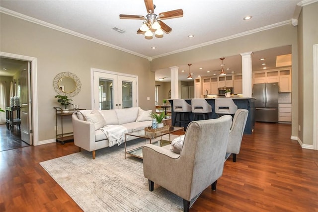 living area featuring french doors, decorative columns, crown molding, visible vents, and dark wood-type flooring