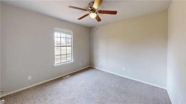 carpeted empty room featuring a ceiling fan, visible vents, and baseboards