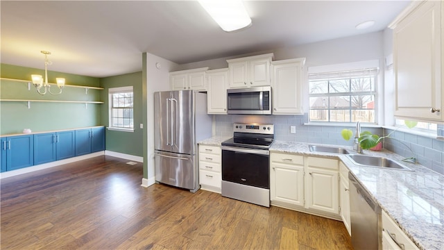 kitchen with dark wood-style floors, white cabinetry, stainless steel appliances, and a sink