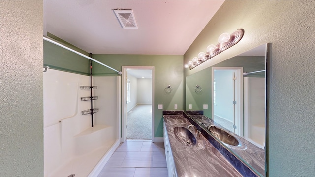 bathroom with a shower, visible vents, vanity, baseboards, and tile patterned floors