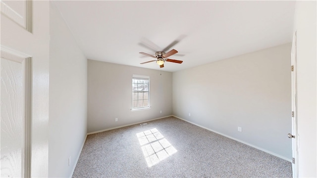 spare room with carpet floors, visible vents, baseboards, and a ceiling fan