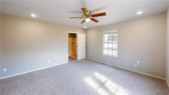 unfurnished bedroom with light carpet, a spacious closet, recessed lighting, and baseboards