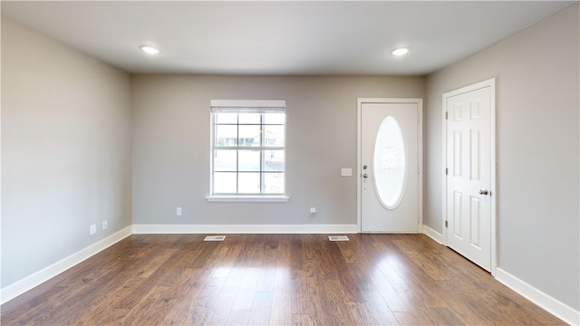 foyer entrance with dark wood-style floors, baseboards, visible vents, and recessed lighting