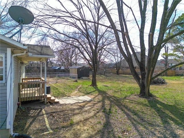 view of yard with an outdoor structure, a storage shed, and fence