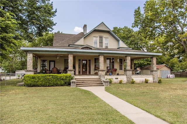 view of front facade with covered porch, a chimney, fence, and a front lawn