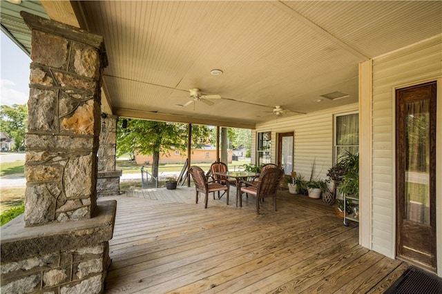 deck with outdoor dining area and ceiling fan