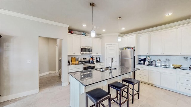 kitchen with appliances with stainless steel finishes, a sink, a kitchen breakfast bar, and tasteful backsplash