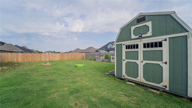 view of yard featuring a storage unit, an outdoor structure, and a fenced backyard