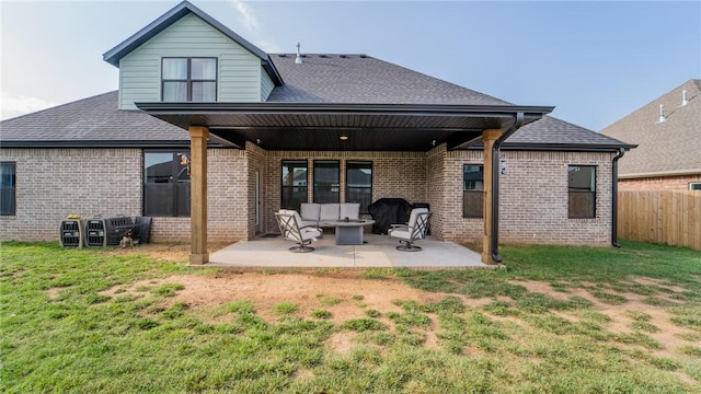 back of house featuring brick siding, a lawn, and a patio