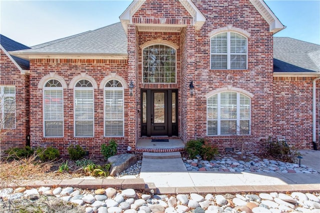 view of front of home with a shingled roof and brick siding