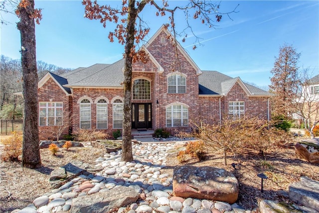 view of front of home featuring a shingled roof and brick siding