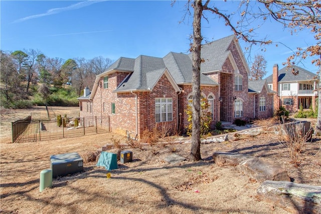 view of property exterior with brick siding and fence