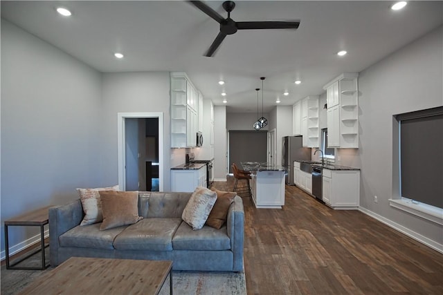 living area featuring dark wood-style floors, ceiling fan, baseboards, and recessed lighting