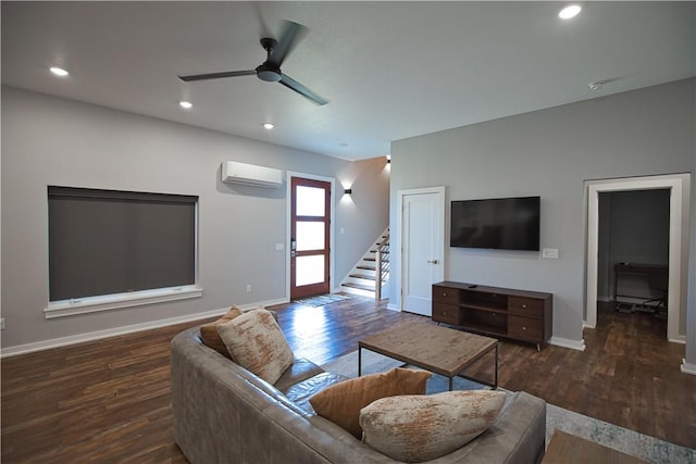 living room with a wall unit AC, stairs, and wood finished floors