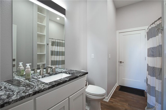 full bathroom with baseboards, vanity, toilet, and wood finished floors