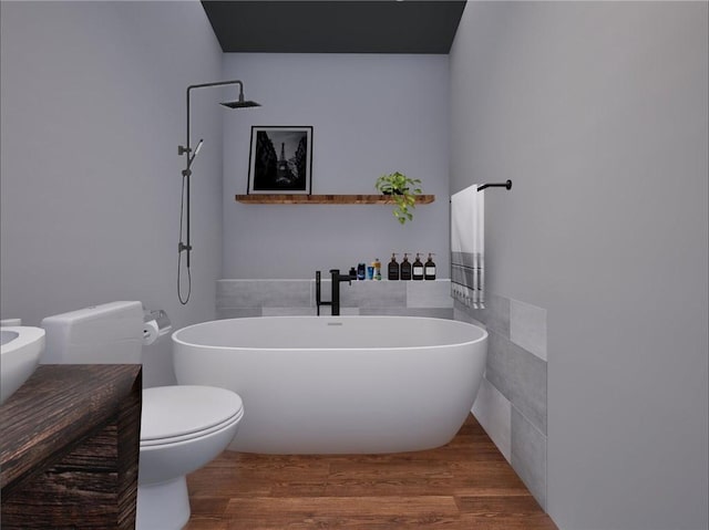 bathroom with a freestanding bath, wood finished floors, and toilet