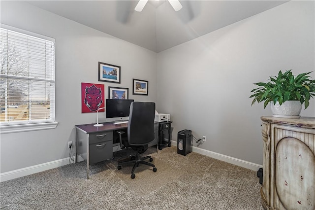 carpeted home office featuring a ceiling fan, baseboards, and vaulted ceiling