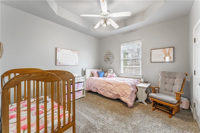 bedroom featuring a raised ceiling, a ceiling fan, and carpet floors