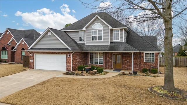 traditional-style home with brick siding, driveway, a garage, and fence