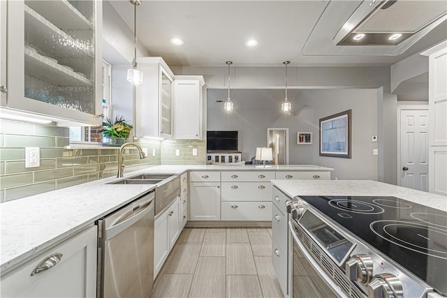 kitchen featuring backsplash, glass insert cabinets, light stone countertops, stainless steel appliances, and a sink