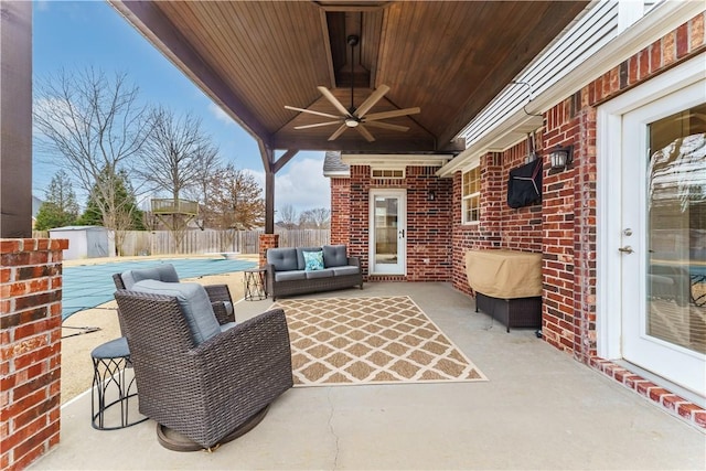 view of patio with an outdoor hangout area, a fenced backyard, a fenced in pool, and ceiling fan