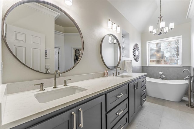 bathroom with tile patterned floors, a soaking tub, double vanity, and a sink