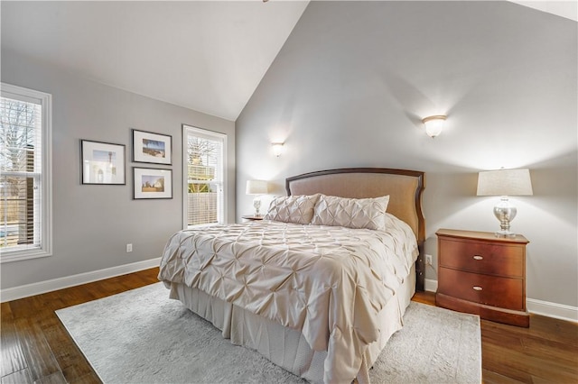 bedroom featuring lofted ceiling, baseboards, and wood finished floors